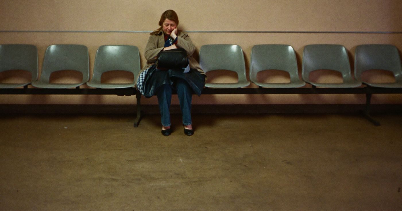 Une femme seule, assise dans une rangée de chaises vides